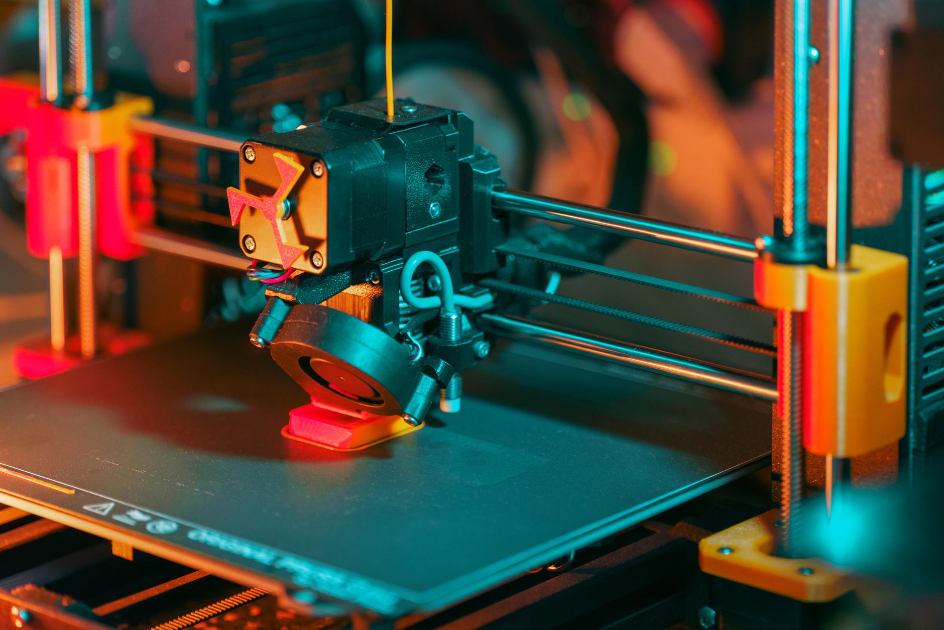 Bico de impressora 3D depositando filamento derretido em detalhe macro